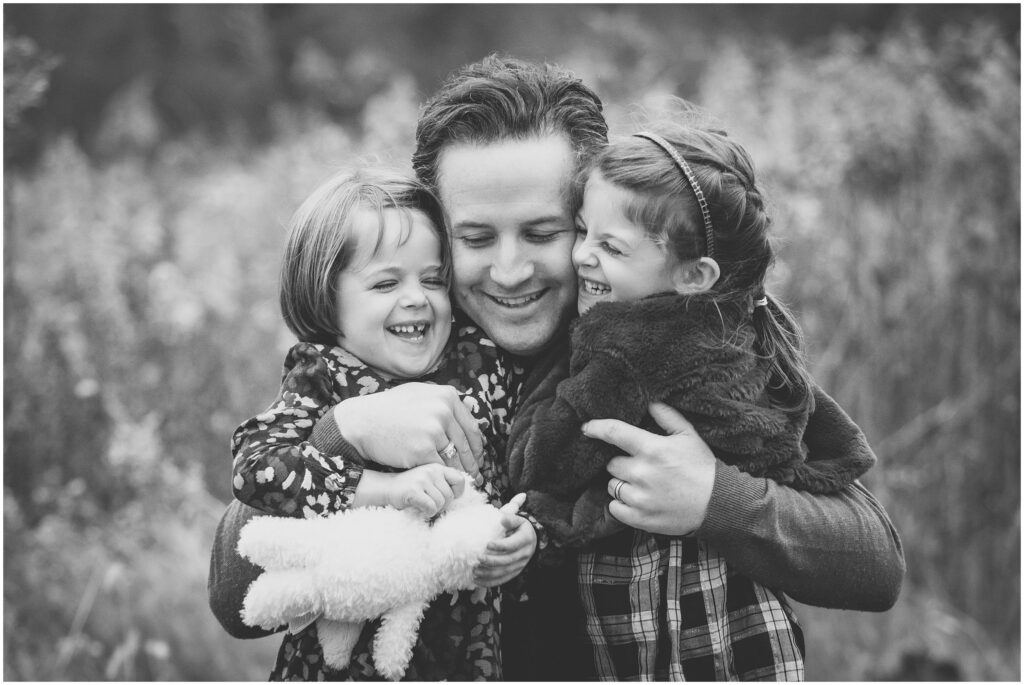 Dad hugging daughters