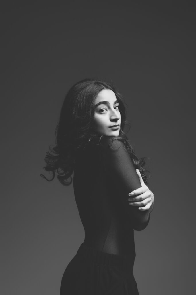 Dancer hugging herself looking sideways to the camera