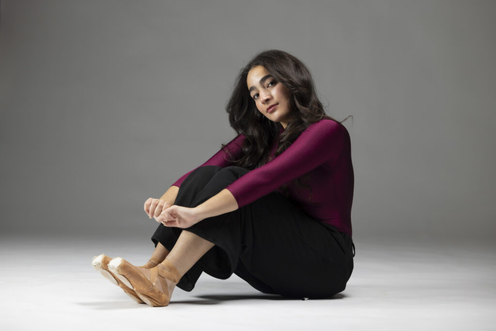 Dancer sitting on the floor of a studio